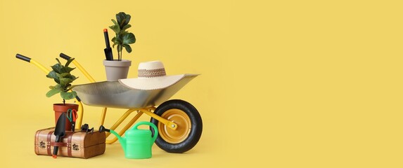 Wheelbarrow with plants and gardening supplies on yellow background with space for text
