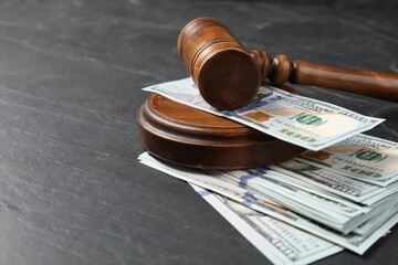 Judge's gavel and money on dark grey table, closeup. Space for text