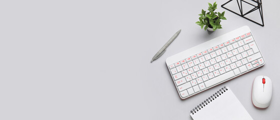 Wireless keyboard with computer mouse and office stationery on light background with space for text