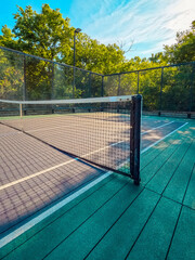 Summertime scene of elevated sport courts with nets in a public park setting. Courts are used for...
