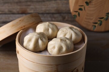 Delicious bao buns (baozi) on wooden table, closeup