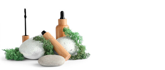 Mascara, bottle of serum, green moss and stones on light background with space for text