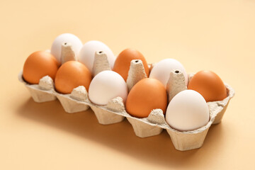 Eggs in carton box on beige background