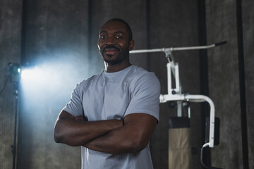 Fototapeta na wymiar Fitness workout in gym. Portrait of African American man standing in gym with motivation health energy ready for training. Athletic coach personal trainer fitness club owner. Healthy lifestyle