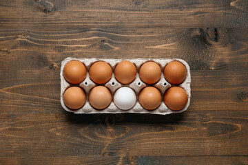 Eggs in carton box on wooden background