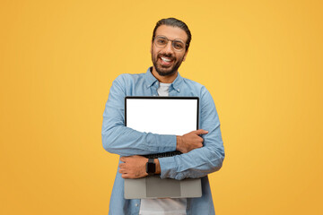Man hugging laptop with blank screen