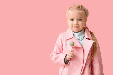 Cute little girl with sweet lollipop on pink background