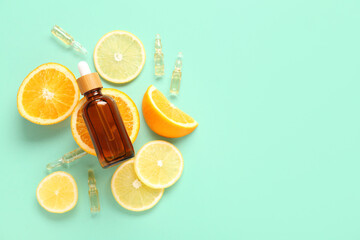 Bottle and ampules of vitamin c with citrus slices on turquoise background