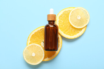 Bottle of vitamin C with citrus fruits slices on blue background