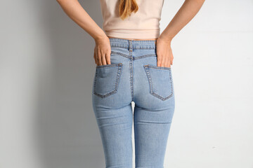 Young woman in stylish jeans pants on white background, back view - obrazy, fototapety, plakaty