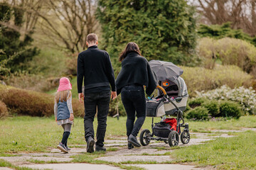 Rodzina z dzieckiem na spacerze w parku