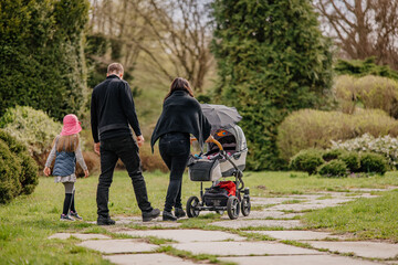 Rodzina z dzieckiem na spacerze w parku - obrazy, fototapety, plakaty