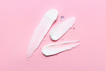 Samples of cosmetic cream on pink background