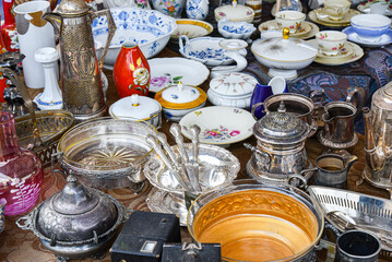 Vintage antique items on table flea market, garage sale of ceramic plates and cups. - Powered by Adobe