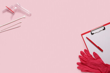 Clipboard with medical gloves, gynecological speculum and pap smear test tools on pink background
