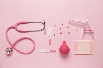 Stethoscope with gynecological speculum, pills and pregnancy tests on pink background © Pixel-Shot