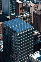 Top view of a solar panel array on the roof of a commercial building in an urban setting.