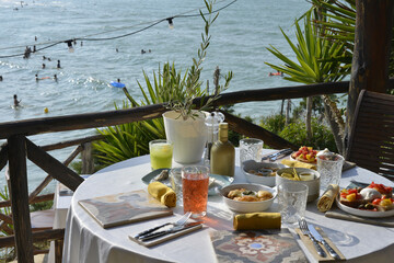 cocktail servito con un abbondante aperitivo servito in un bar in riva al mare - 773476226