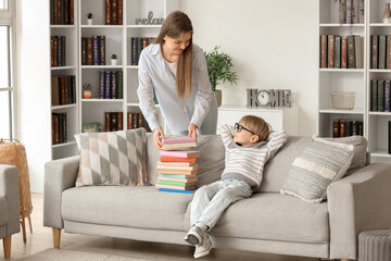 Cute little boy and his mother with different books at home - obrazy, fototapety, plakaty