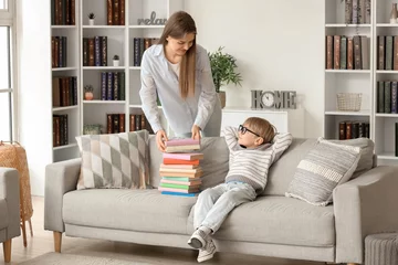 Fotobehang Cute little boy and his mother with different books at home © Pixel-Shot