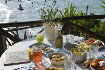 cocktail servito con un abbondante aperitivo servito in un bar in riva al mare - 773476264