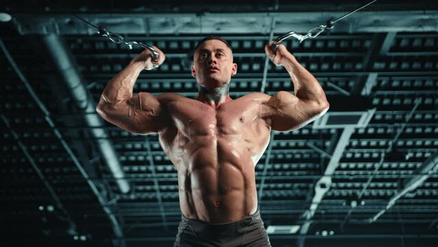 Muscular bodybuilder performing bicep workouts at a crossover cable machine, displaying strength and dedication in a gym setting. Camera 8K RAW. 
