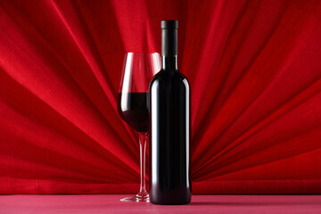 Stylish presentation of delicious red wine in bottle and glass on color background