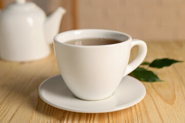 Obraz premium Tasty tea in cup on light wooden table, closeup