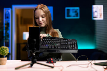 Content creator typing on mechanical keyboard while doing review in personal studio to see if price is justified. Technology guru showcasing computer peripheral features to fans - obrazy, fototapety, plakaty