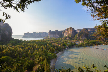 Scenic landscape of the lush Railay peninsula with steep limestone karst cliffs and mountains viewed from above on a sunny day in Krabi, Thailand.