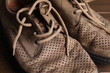 Poverty. Old shoes on wooden table, closeup