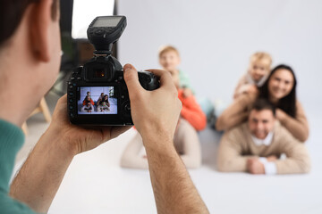 Male photographer taking picture of big family in studio, closeup