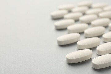 Vitamin pills on light grey background, closeup with pace for text. Health supplement