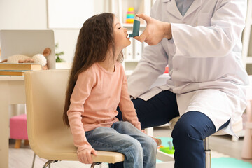 Little girl with doctor using inhaler in clinic - obrazy, fototapety, plakaty