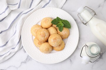 Tasty sweet sugar cookies, milk and mint on white marble table, top view
