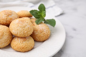 Tasty sweet sugar cookies and mint on white marble table, closeup