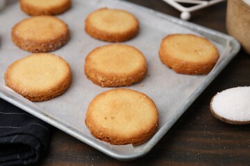 Tray with tasty sweet sugar cookies on wooden table, closeup
