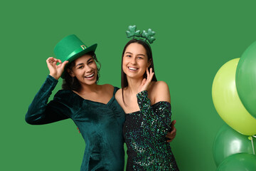 Beautiful young women and air balloons on green background. St. Patrick's Day celebration