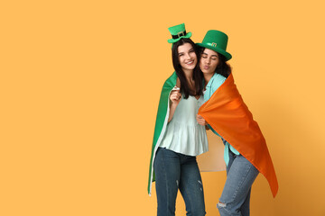 Beautiful young women with Irish flag on yellow background. St. Patrick's Day celebration