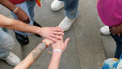 Homosexual diverse group of young people stacking hands together outdoors. LGBTQ community concept with multiracial friends celebrating gay pride festival day - Powered by Adobe