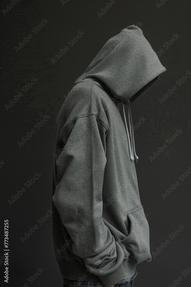 Poster a man in a gray hoodie standing with hands in pockets. suitable for various concepts
