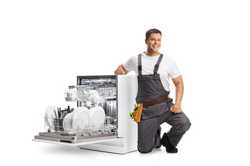 Repairman kneeling next to a dish washer and smiling