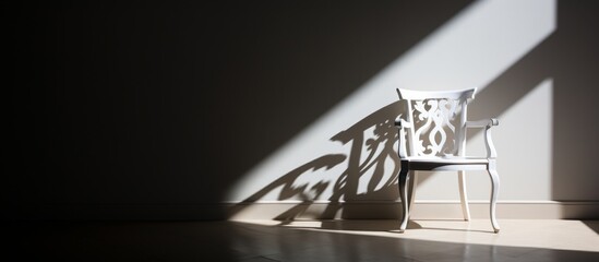 A simple white chair sits elegantly in a room, casting a shadow on the wall behind it