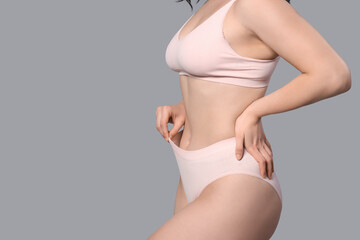 Beautiful young body positive woman in stylish underwear on grey background, closeup - obrazy, fototapety, plakaty