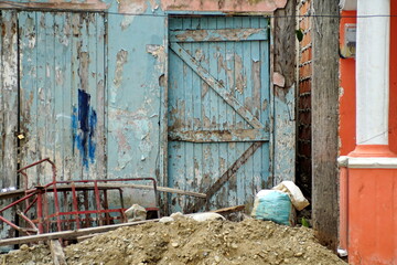 Trash in front of a building with blue, peeling paint in Limones, Esmereldas, Ecuador
