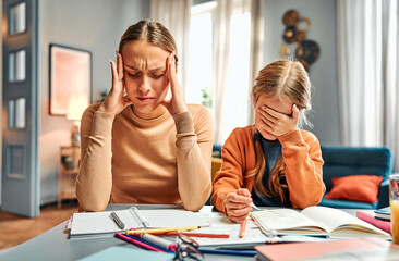 Concept of stressful parenthood. Frustrated daughter having difficulties with homework next to mum