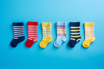 Many different mismatched baby kid socks on light blue background. Odd Socks Day, Lonely Sock Day,...