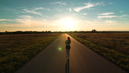 silhouette sports girl running along road sunset, ready triathlon, legs athlete running road,...