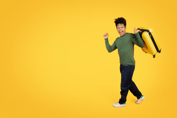 Joyful man running with a yellow suitcase