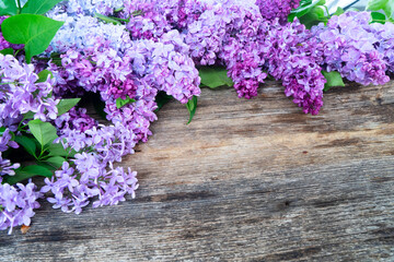 Fresh lilac flowers over wooden background with copy space, flat lay floral composition with copy space